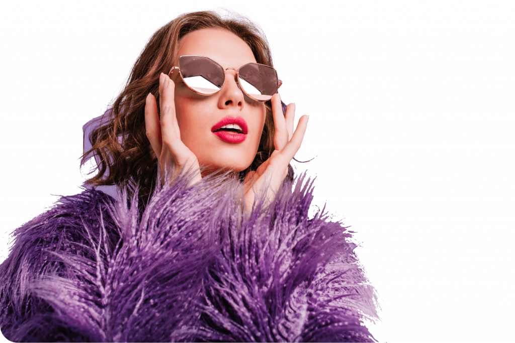 Femme audacieuse portant un manteau en fausse fourrure recyclée violette et des lunettes de soleil, incarnant le luxe éthique de la marque Etikashion.