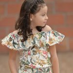 Jeune fille portant une combinaison à motif floral en coton biologique Etikashion, une tenue confortable et éco-responsable pour enfants.